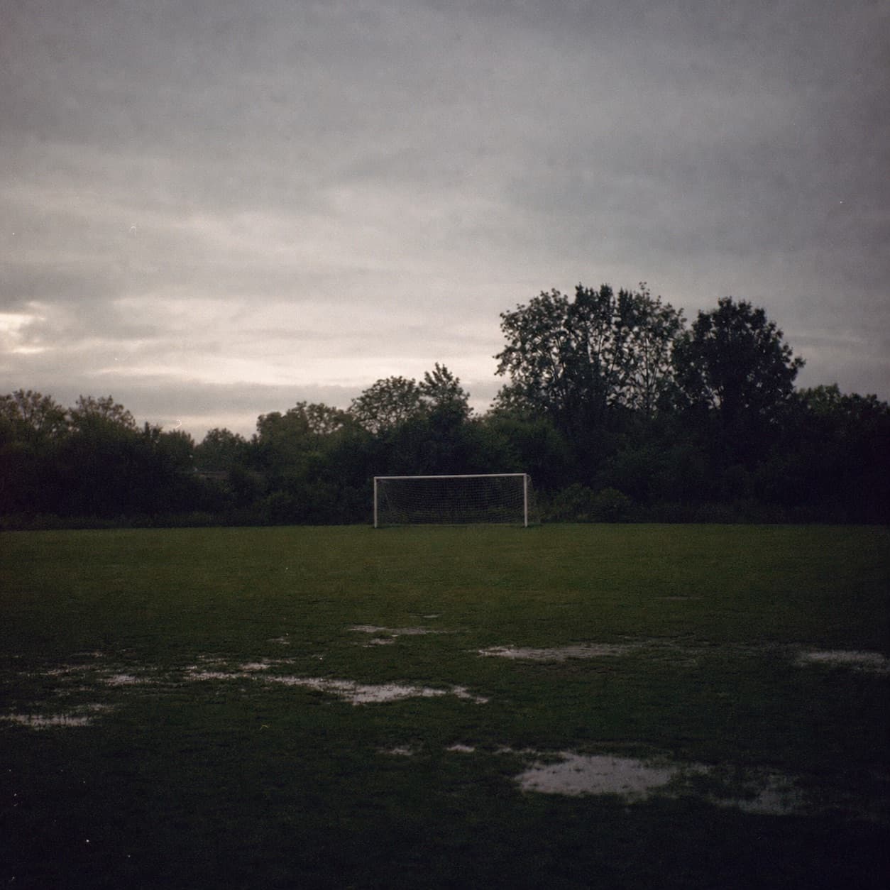 An empty neighborhood soccer field after rain